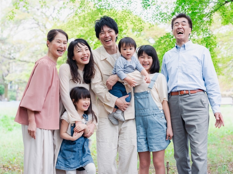 Asian American family laughing and enjoying time outdoors.